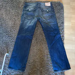 True Religion Jeans i straight passform som ligger bra över skorna medans dom inte är smala. Jeansen är storlek 36 i nästintill ny skick då jag nästan aldrig använder dom. Skriv om du har några mer frågor eller vill ha mer bilder på dom!