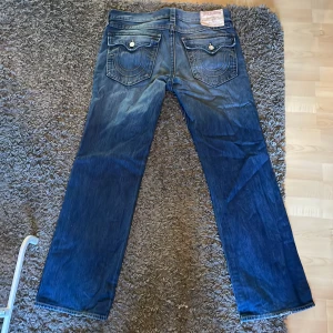 True Religion Jeans - True Religion Jeans i straight passform som ligger bra över skorna medans dom inte är smala. Jeansen är storlek 36 i nästintill ny skick då jag nästan aldrig använder dom. Skriv om du har några mer frågor eller vill ha mer bilder på dom!