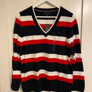 Tommy Hilfiger tröja  - Randig tröja från Tommy Hilfiger i strl L. Marinblå, röd och vit.  Helt ny, aldrig använd. 