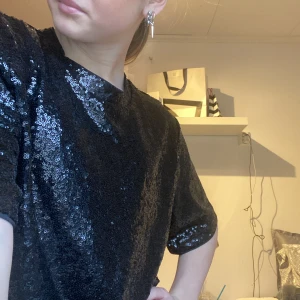 Svartglittrig topp från hm - En jättefin glittrig topp från hm lite kroppad perfekt till nyår och julafton men passa även till fest 🎉!!nypris:300