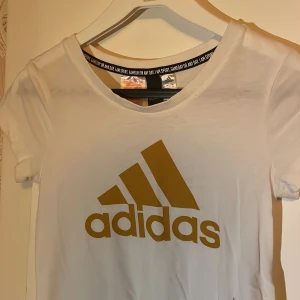 vit adidas tshirt - säljer då den inte används☺️ Väldigt skönt material, dock det är lite lite genomskinligt💕 tröjan har en fläck som jag inte tror går bort☺️