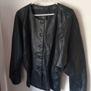 Svart skinnjacka /blus stl M. - Fin och välvårdad Skinnjacka svart i storlek M ,knäppes med knappar och lite figur sydd.Hämtas i Skene alt skickas o köpare betalar frakten o Swishbetalning tillämpas . Av märket Mattssons Sweden .Inget slitage finnes .