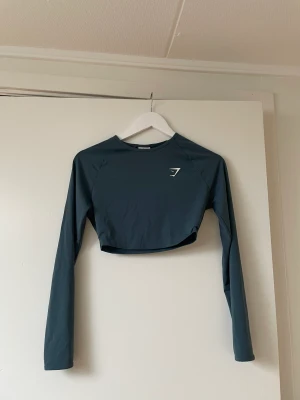 Long sleeve crop top  - En long sleeve crop tog från gymshark . Färgen är mörkblå och i fint skick. Använd få gånger. På hemsidan kostar den cirka 250 kr men säljs för 100. Köparen står för frakten