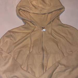 Gul kort zip hoodie  - Säljer denna gula tröja från H&M. Den är använd ungefär 3 gånger. Storlek: M Säljer för att jag nästan aldrig använder den.