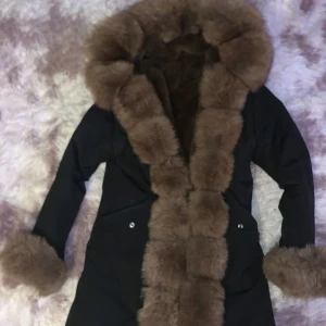 Svart Jacka med brun päls. - Säljer denna jacka pga av att jag tycker att den är för lång. Den är andvänd men knappt några synliga fel förutom att pälsen är lite utnött vid händerna men de syns knappt när den är på. Varm. Du står för frakten. Pris kan diskuteras. Kostar ca 3000kr ny