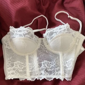 Urban korsett  - Super snygg vit spets korsett som tyvärr inte passar mig, har en liten rosa fläck på ryggen (se på andra bilden) men annars så är korsetten i gott skick🤍