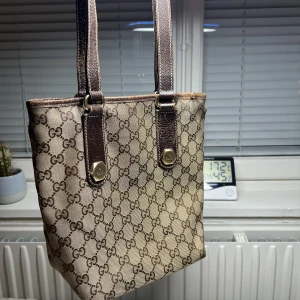 Gucciväska - Säljer min Gucciväska som jag köpt Second hand 2021.   Modell: Monogram Charmy Tote (small)  Väskan har tecken på användning som på bilderna men är i bra skick.  Äkthetsbevis finns 🤍