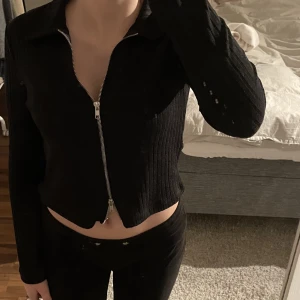 Svart tröja med dragkedja - En långärmad svart tröja med dragkedja som går att dra i både nerifrån och uppifrån. Jättebra skick. Köpare står för frakt. Skriv privat vid intresse eller frågor. 