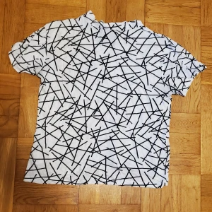 Svartvit t-shirt  - Svartvit t-shirt från Saints & Mortals, köpt på Carlings. Luftig, tunt och skönt material. Okej att komma med bud. Katt i hemmet.