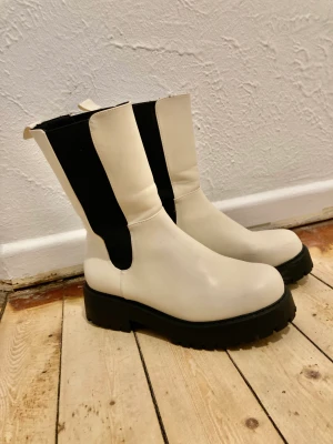Monki stövlar / Chelsea boots - Ett par lite högre chelsea boots från Monki, enbart använda 2 gånger. Felfritt skick förrutom några svaga svarta streck vsom syns på bilderna. Kan förmodligen putsas bort. 