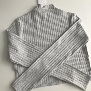 Grå tröja - Detta är en helt ny tröja från H&m. Har aldrig använts och har kvar prislappen då den var för stor.
