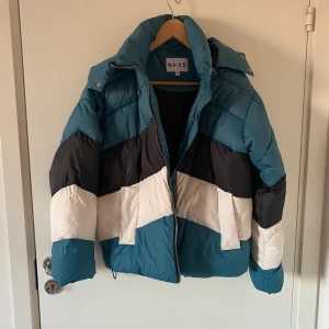 Jacka i multifärg NA-KD - Jacka i multifärg, (blå svart och vitt) från NA-KD i bra skick. Använd ett par gånger. Normal passform.