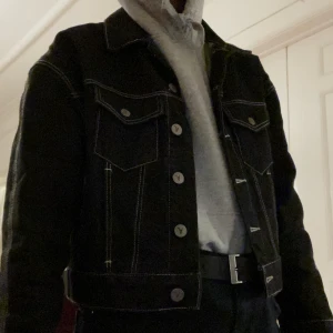 Svart Jeansjacka med Vita sömmar  - Jättesnygg svart jeansjacka m. vita sömmar! Från Asos. Står ingen storlek men gissar på XS/S. För referens är jag 160cm (bild 1). Lappen man hänger den i sitter också lite löst. Från rökfritt och djurfritt hem. Kan mötas i Centrala Stockholm eller frakta!