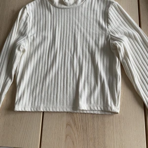 Långärmad topp - Vit tröja med ganska hög krage och långa ärmar. Storlek s men är som en xs