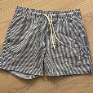 Badshorts Gant  - Blå- och vitrandiga badshorts Gant storlek S. Endast använda ett fåtal gånger
