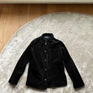 Manchesterkavaj-sammet - Stilig manchesterkavaj/over shirt i svart från A Day’s March. Storlek: S