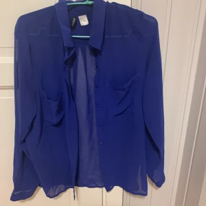 Tunn långärmad skjorta i storlek 36 - Tunn långärmad blå skjorta i lite genomskinligt tyg från H&M i storlek 36. Använd vid några enstaka tillfällen. 