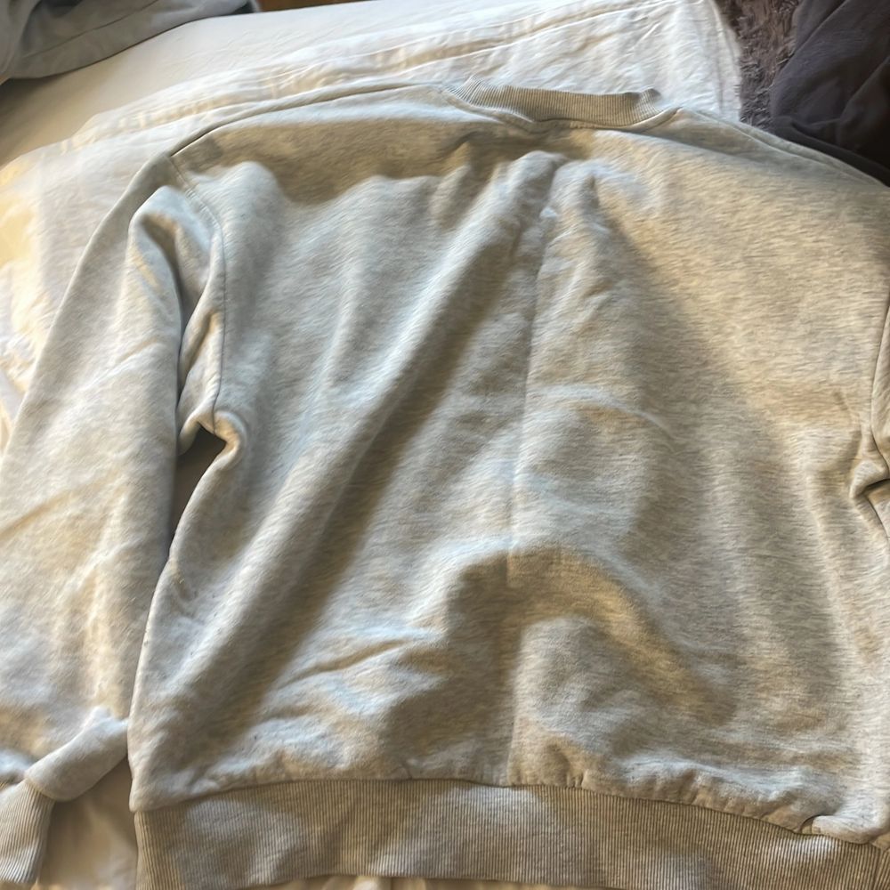 En grå sweatshirt med tryck på framsidan. Denna tröja är otroligt bekväm och mysig. Sweatshirten köptes för 2 år sedan och användes mycket under 2020, tröjan är fortsatt i bra skick och trycket sitter perfekt! Betalning sker via swich:). Huvtröjor & Träningströjor.