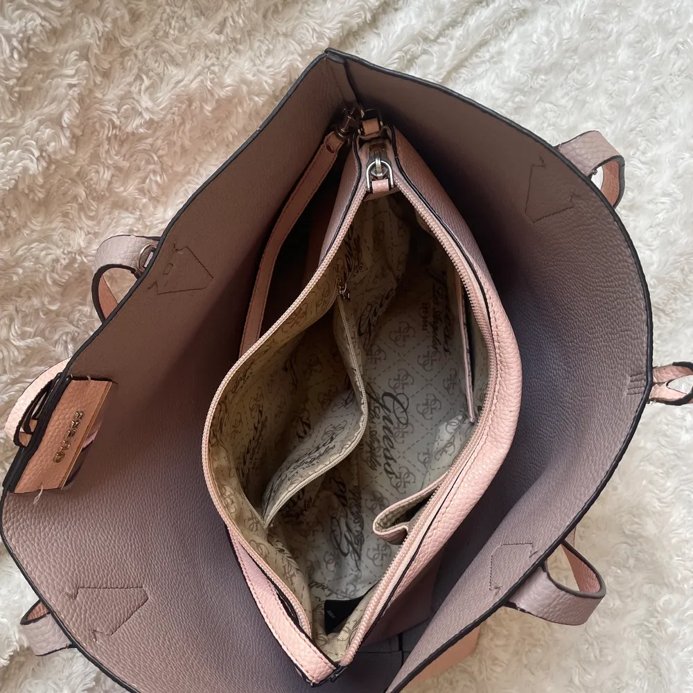 Stor väska från Guess, köpt för längesedan o glömts bort tyvärr varpå jag säljer, sparsamt använd. Kommer med en väska inuti som med fördel används separat. Måtten är ca 45 cm bredd och 30 cm i längd . Väskor.
