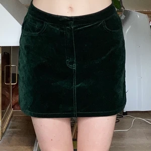 Grön sammetskjol från weekday strl 38 - Jättfin mörkgrön sammetskjol från weekday! Passar strl 36/38. Den är i fint skick men har nån enstaka tråd som sticker ut. 