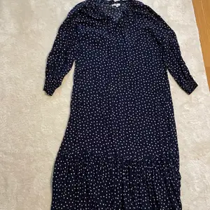 En mörkblå lång klänning med vita och röda prickar. Den är från Hampton Republic i storlek L. Har endast användes ett få tal gånger. 