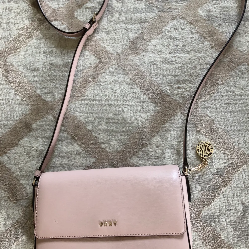 Jag säljer denna fina axelremsväska från DKNY i en vacker ljusrosa färg. Använd en gång. Kvittot finns tyvärr inte kvar men dustbag finns i väldigt gott skick, som sagt, väskan är använd en gång och det finns inget att anmärka på. Nypris 1700.. Laukut & Käsilaukut.