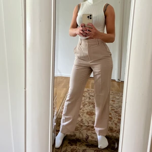 Kostymbyxor - Beiga kostymbyxor från NA-KD, sköna med bra passform! Längden är perfekt för mig som är 160 cm, storlek xs men relativt stora i storleken. Byxorna är endast använda några enstaka gånger så de är i väldigt gott skick!🥰