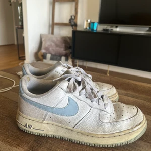 Nike air force - Vita Nike air force med blåa detaljer. Storlek 40. Använda en del men längesen sist. Lite smutsiga men i bra skick annars! 