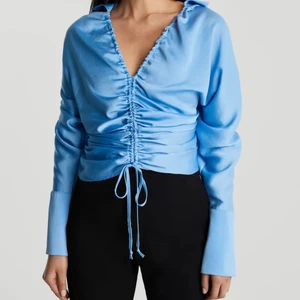 Blus - Ljusblå blus i glansigt material ifrån Ginatricot. Går att reglera knytningen framtill. Endast använd 1 gång så i gott skick! 💙 *Frakt tillkommer!