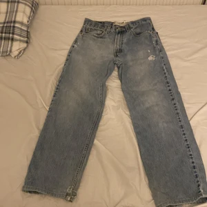 Levis 330 30x31 - Snygga ljusblåa Levis byxor i relaxed fit! De har ett litet hål i hälen och på främre låret men annars i bra skick! 