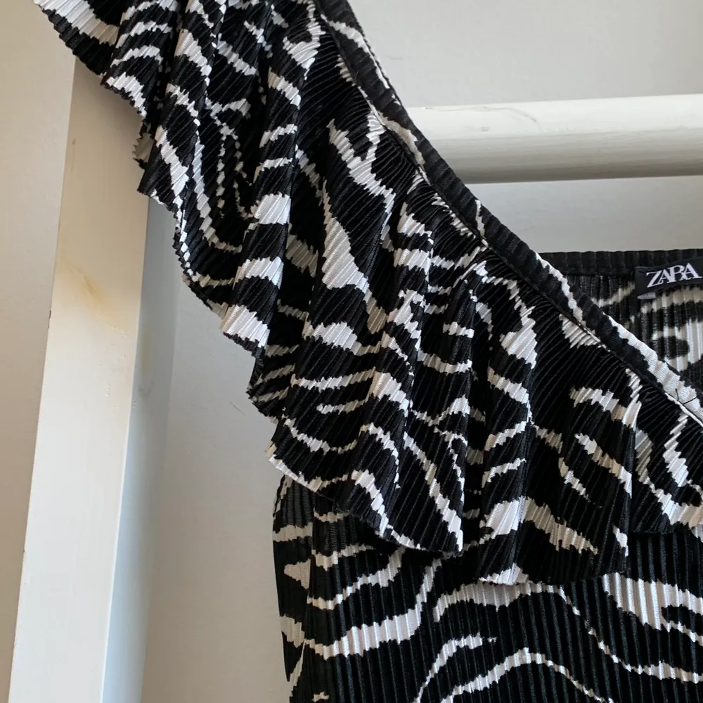 Superfint zebramönstrat linne från zara med volanger. Den har snören som är justerbara. Använd några gånger men i gott skick. Superfin till ett var vita eller svara byxor. (Hund finns i hemmet)💕. Toppar.