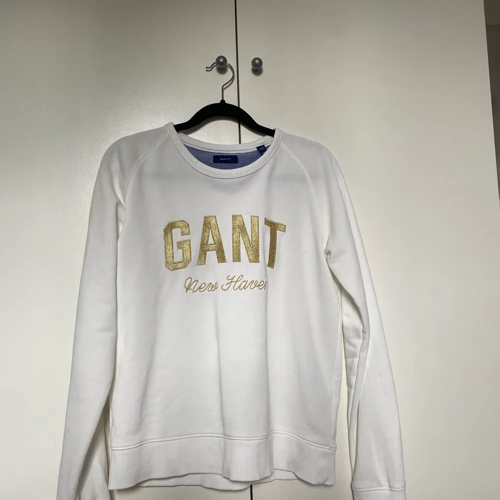 Tröja från gant. Vit med guldig text. Storlek 170. Passar XS och S. Köparen står för frakten. Neuletakit & Villapaidat.