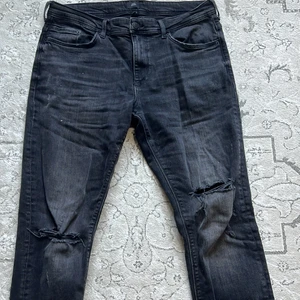 River Island Ripped Jeans 34/32 Svarta - Gick ur rippedjeans fasen innan jag hann ta på mig de, så de är helt nya… Den brukar kosta runt 600kr? Så jag säljer det för hälften trots att den är helt ny 😅🤷‍♂️ Den passar perfekt också, på mig iaf! (Jag är 176 cm o väger runt 76kg)