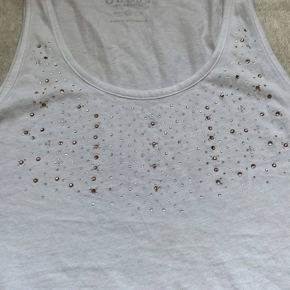 Guess linnne vitt med Cristaljer vid bröstkorgen är u ringad i storlek S-M . T-shirts.