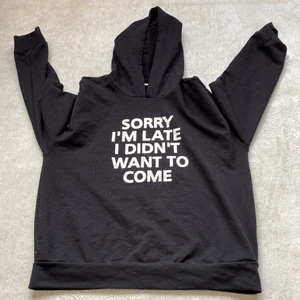 Hoodie - Det är en svart hoodi som är svart och har text på