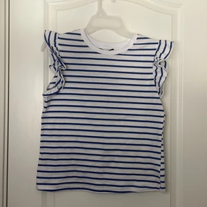 En randig volang T shirt i storlek XS/S❤️ - En fin randig kort armad volang t- shirt parfekt till sommaren. Jag säljer denna fina T- shirt eftersom den tyvvär inte kommer till användning längre.❤️