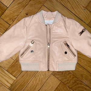 Oanvänd rosa skinnjacka stl 6-12mån  - Aldrig använd med lapp kvar. Finns att hämta på Södermalm eller skickas mot frakt. 
