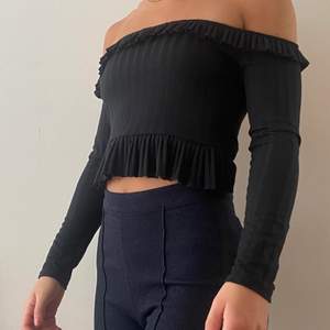 Croppad svart off shoulder topp. På andra bilden såg jag att den nedre volangen fastnat innanför tröjan. Volangen följer hela vägen runt.