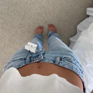 Zara mid raise jeans  - Ljus blåa zara mid raise jeans. Helt slutsålda på deras hemsida. Köpta här på Plick med pris lapp kvar, prislappen är inte kvar längre och jeansen är endast använda en gång så i bra skick. Köpta för 299 och säljer för 200kr. Storlek 34. Säljer likadana i washed black. Köp direkt för 300kr + frakt.