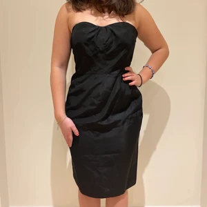 Cocktailklänning från Oasis - Jättefin bandeuklänning från Oasis med unik baksida! En classy men bekväm svart klänning. Storlek 38 och i superbra skick.