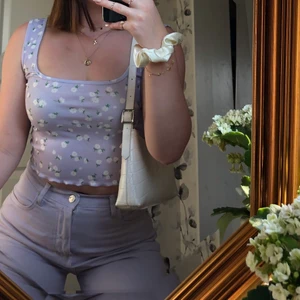 Linne - Jättegulligt linne med vita blommor på. Storlek S. Sparsamt använd! Säljer även de lila jeansen på bilden :) Köparen står för frakten 🥰