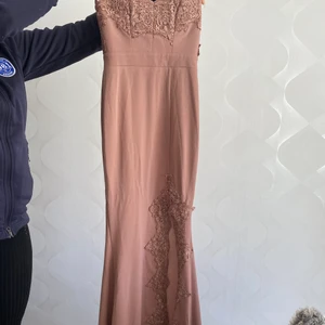 Rosa lång klänning - Haft den på min bal 1 gång. Storlek XS , har lite släp bak om man är kort ( 158 cm ) har en slit på sidan. Passar inte nån som har större bröst än C kupa