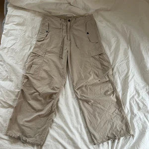 Parachute/cargos - Fett snygga parachute/cargopants från Blend! Storlek L men kan dras åt både i midjan och längst ner i benen så passar mindre storlekar. Liiite smutsigt och pyttelite slitet längst ner, de tvättas innan och kan skicka bild om man vill ha det!