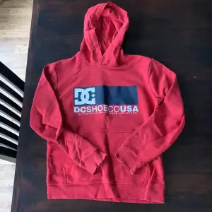 En röd dcshoecousa hoodie i storlek 12 år