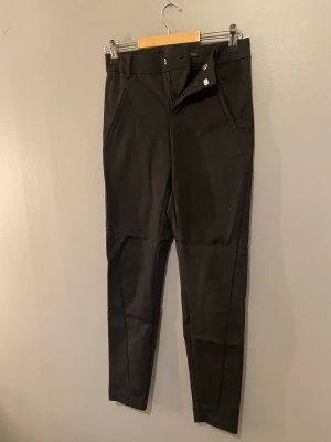 Kostymbyxa svart  - Säljer dessa svarta kostymbyxor från Vero moda, vet ej när dessa är köpte eller hur mycket dom kostade men tänkte mig 200kr för dom, billigare vid snabb affär, dom är i storlek XXS/34. fickor fram och baksida. 