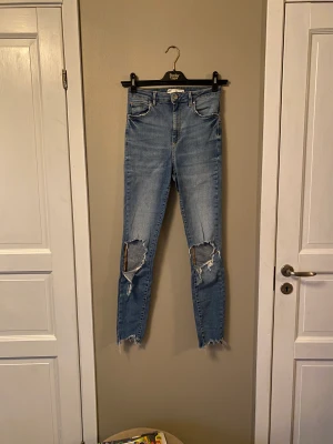 gina tricot jeans - begagnade blåa håliga gina jeans  vid intresse kan fler bilder skickas 