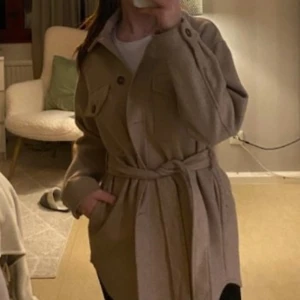 Kappa - Beige kappa från Zara använd 1 säsong. Strl S men bandet i midjan gör att den passar allt från XS-M, säljer för 300kr