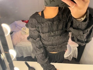 Topp  - En svart tröja med fina detaljer. Storlek 36 alltså S. Är helt oanvänd och är fin till fester.