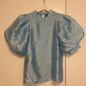 Blå glansig blus - Ljusblå glansig blus med puffärmar! Prislapp kvar och aldrig använd! 