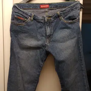 Tighta stretchiga low waist bootcut jeans med strass i brunorangea stenar, vissa har tappats annars fint skick! Perfekt 2000tals look!